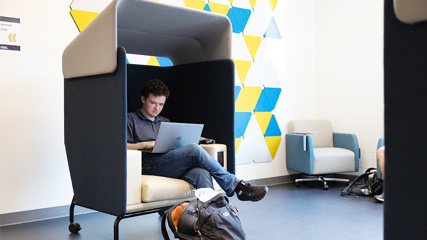 Student works in new movable chair on the second floor of CCB. (Photo by Kevin Beasley/ College of Computing)