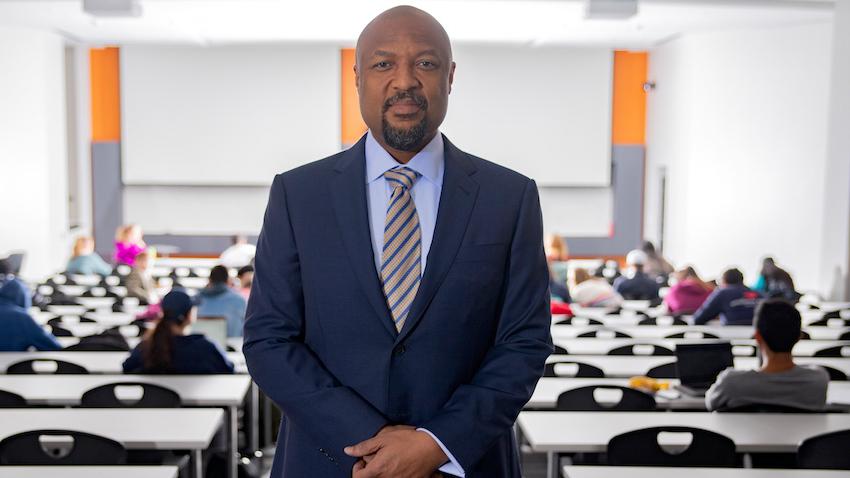 Charles Isbell standing in front of a lecture hall