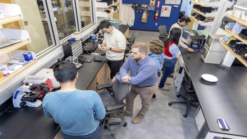 Assistant Professor Alex Adams (center) works with students to design, fabricate, and implement new ubiquitous and wearable sensing systems.