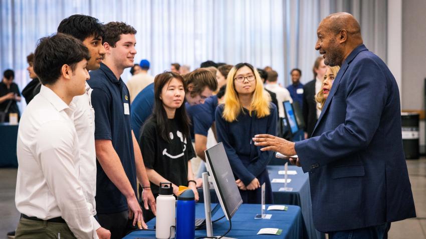 Client and Georgia Tech alumnus Garry Harris speaks with his team at the expo. Photos by Kevin Beasley/ College of Computing.