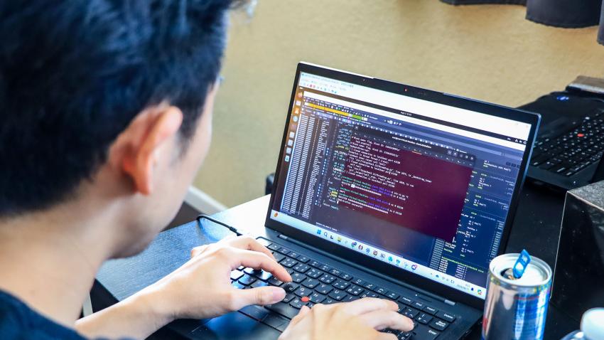 A photo from behind a man as he participates in the capture the flag hacking competition. 