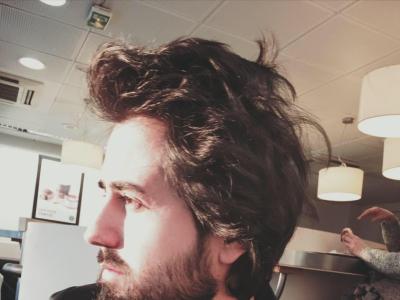 A side profile of a man's face. He has long hair and a beard