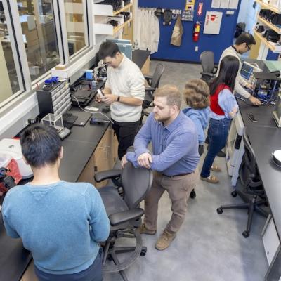 Assistant Professor Alex Adams (center) works with students to design, fabricate, and implement new ubiquitous and wearable sensing systems.