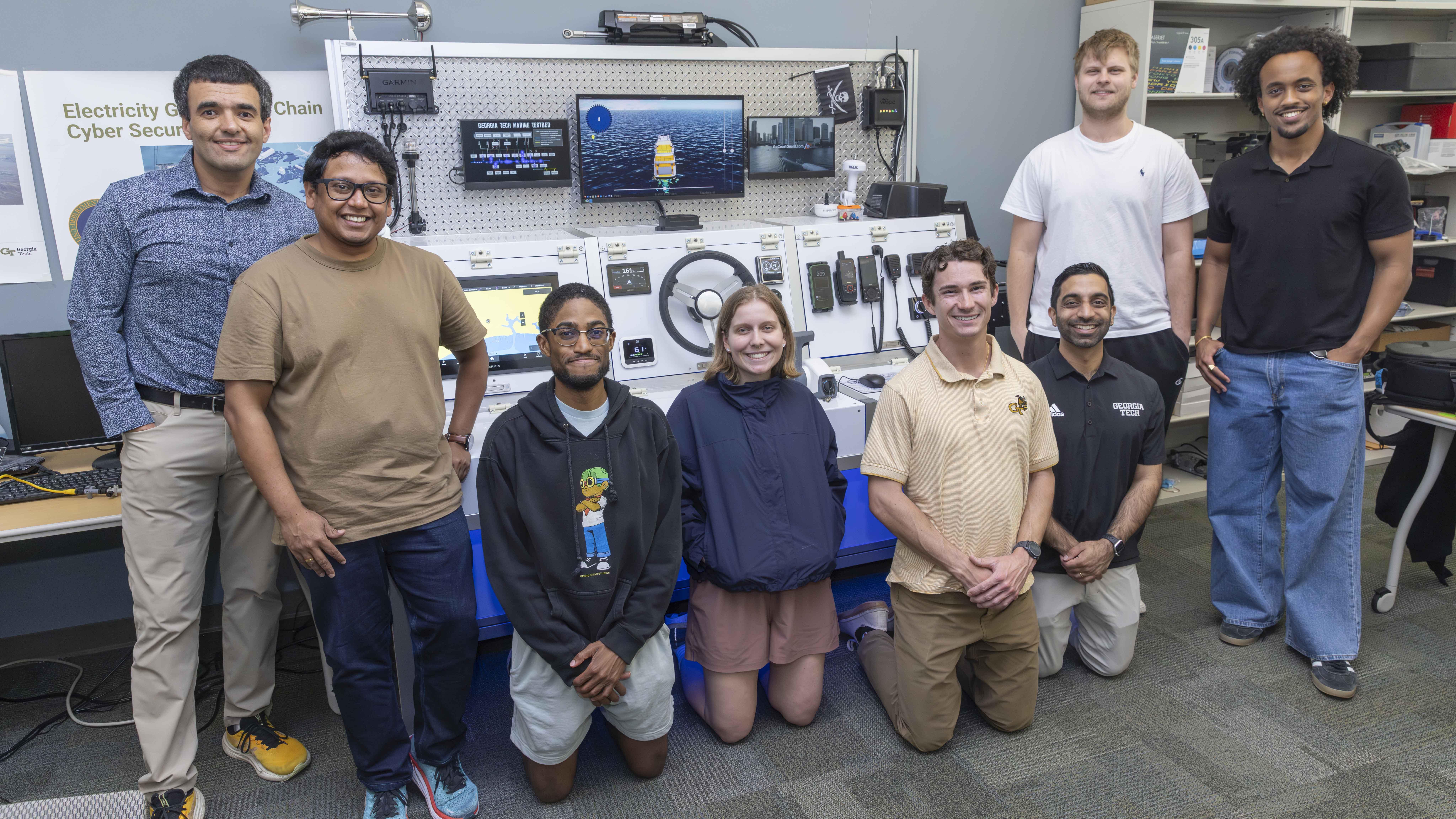 A group photo of students and faculty standing around lab equipment found on a ship. 